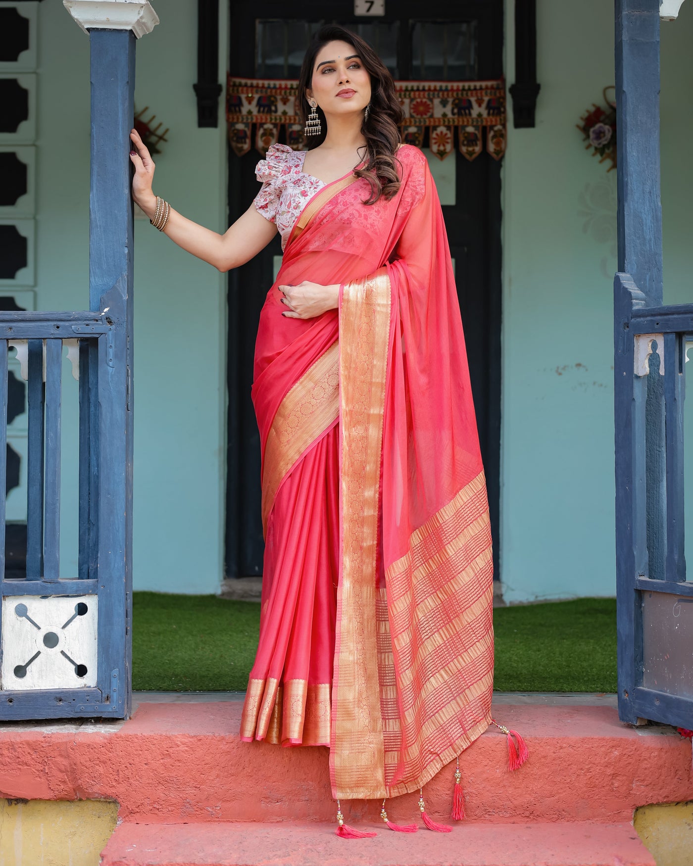 Vibrant Coral Pink Plain Chiffon Saree with Gold Zari Border, Floral Ruffled Blouse & Tassel Detailing