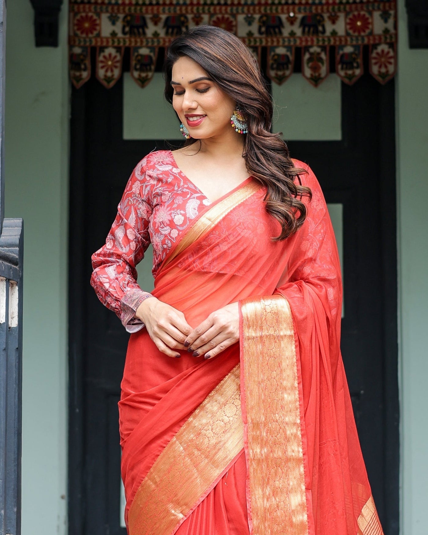 Fiery Red Plain Chiffon Saree with Gold Zari Border, Full-Sleeve Floral Blouse & Tassel Detailing